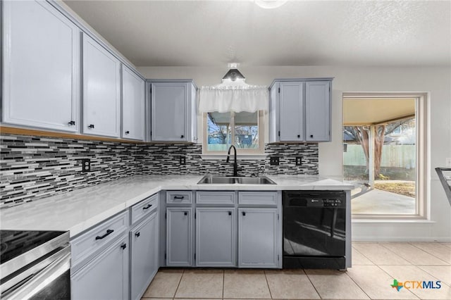 kitchen with sink, gray cabinetry, tasteful backsplash, light tile patterned floors, and black dishwasher