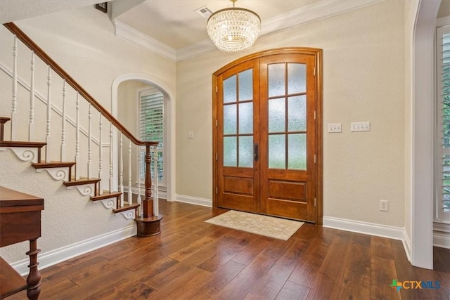 11421 Somerville Dr, Temple, TX 76502 - foyer featuring arched walkways, a chandelier, hardwood / wood-style floors, crown molding, and french doors
