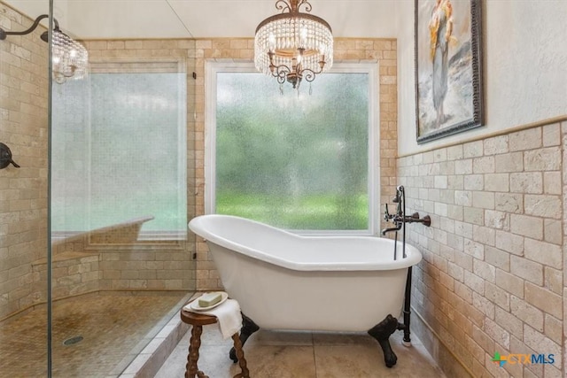 11421 Somerville Dr, Temple, TX 76502 - bathroom featuring a freestanding tub, a tile shower, tile patterned floors, a chandelier, and tile walls