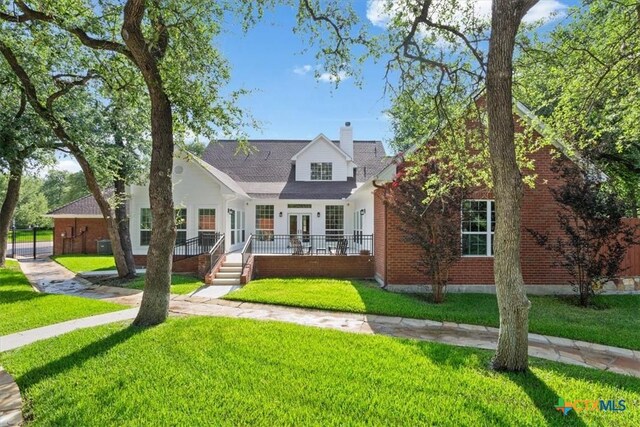 11421 Somerville Dr, Temple, TX 76502 - view of front facade with a front lawn, a chimney, brick siding, and french doors