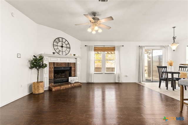 living room featuring dark hardwood / wood-style floors, a fireplace, and vaulted ceiling