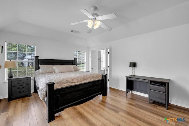 bedroom with vaulted ceiling, light wood-style floors, ceiling fan, baseboards, and visible vents