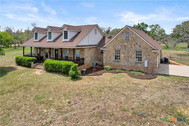 cape cod-style house with fence, a front lawn, central AC, stone siding, and a porch