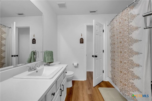 full bath with wood finished floors, visible vents, vanity, and toilet