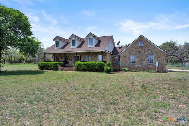 new england style home with a front yard and covered porch