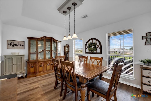 dining room featuring baseboards, wood finished floors, and visible vents
