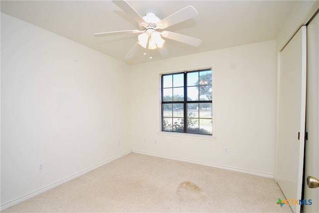 unfurnished bedroom with ceiling fan, light carpet, and a closet