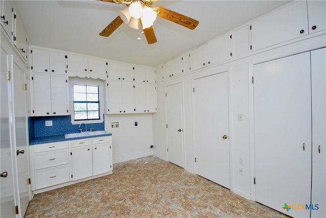 kitchen featuring decorative backsplash, sink, and white cabinets