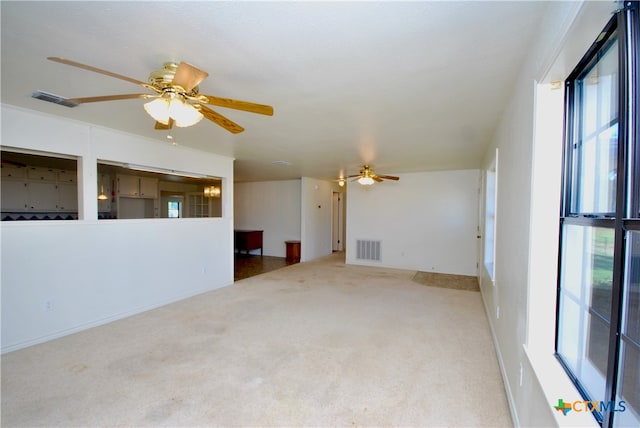 spare room with ceiling fan and light colored carpet