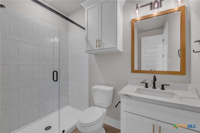 bathroom featuring vanity, toilet, and a shower with door