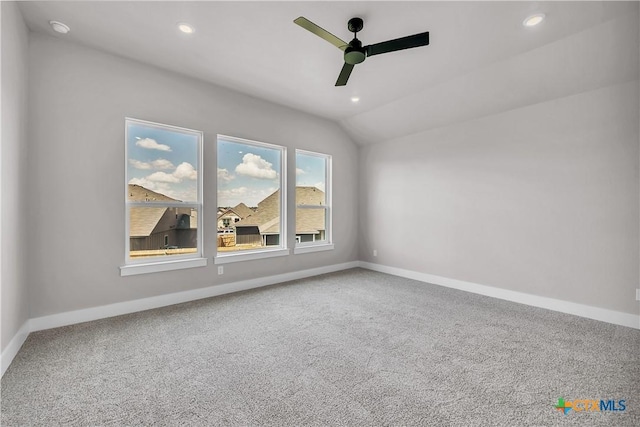 carpeted empty room featuring ceiling fan and vaulted ceiling