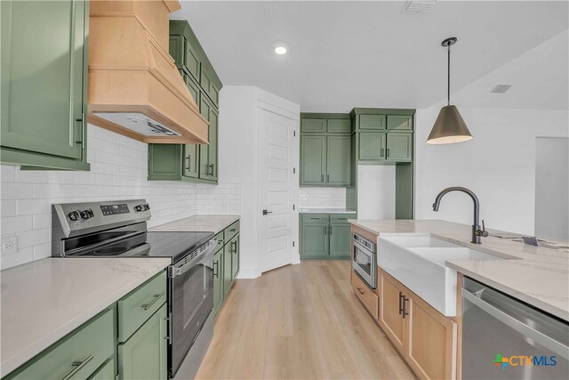 4146 Turning Leaf Dr, Nolanville, TX 76559 - kitchen featuring appliances with stainless steel finishes, premium range hood, and green cabinets