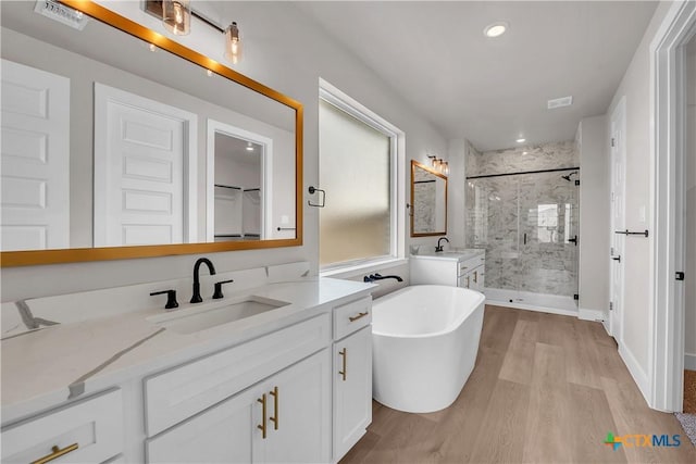 bathroom with hardwood / wood-style flooring, vanity, and separate shower and tub