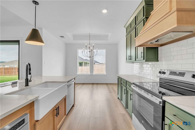 4146 Turning Leaf Dr, Nolanville, TX 76559 - kitchen with premium range hood, a raised ceiling, green cabinetry, appliances with stainless steel finishes, and a notable chandelier