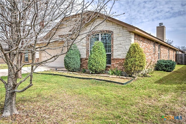 view of property exterior with a garage, a yard, brick siding, and a chimney