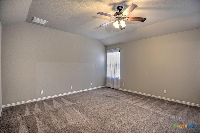 carpeted empty room featuring visible vents, a textured ceiling, baseboards, and vaulted ceiling