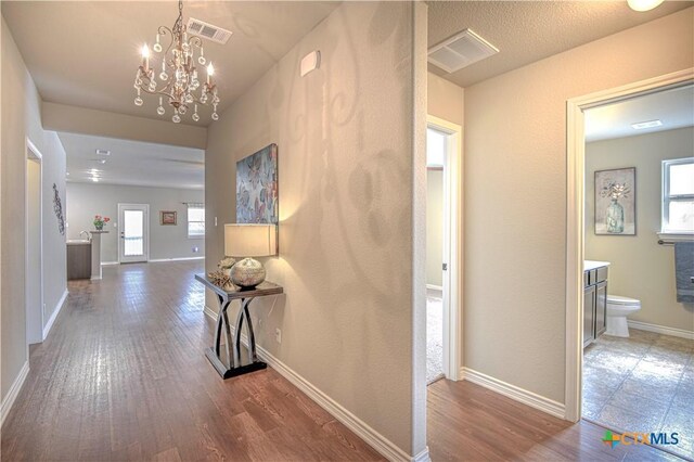 6826 Ambrose Cir, Temple, TX 76502 - unfurnished living room featuring a chandelier, a ceiling fan, dark wood finished floors, a textured ceiling, and a fireplace