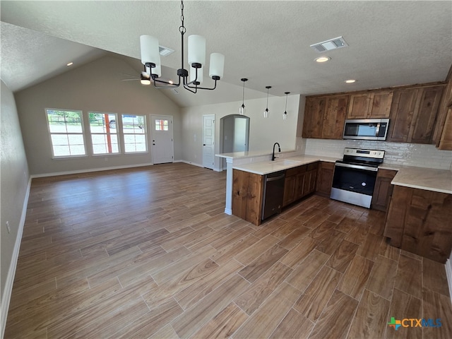 kitchen featuring stainless steel appliances, hardwood / wood-style flooring, and kitchen peninsula