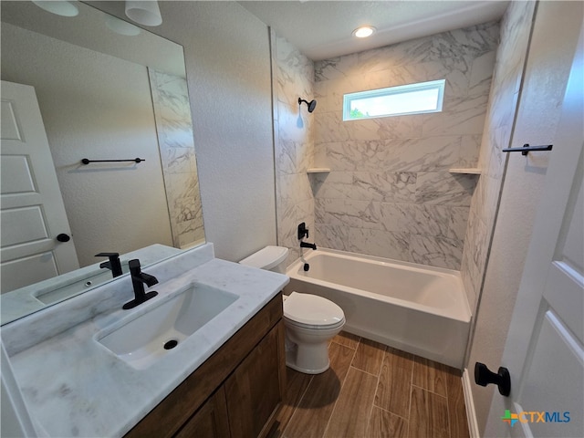 full bathroom with toilet, vanity, and tiled shower / bath