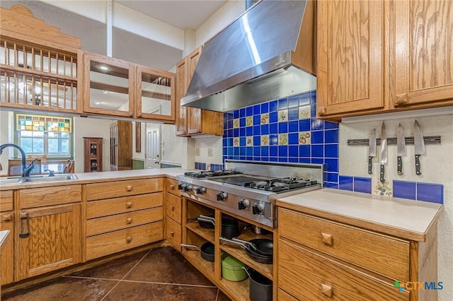 kitchen featuring wall chimney range hood, sink, decorative backsplash, kitchen peninsula, and stainless steel gas stovetop