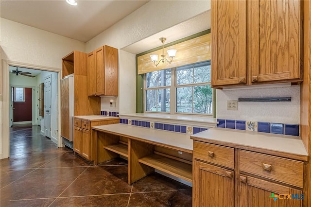 kitchen with hanging light fixtures and ceiling fan with notable chandelier