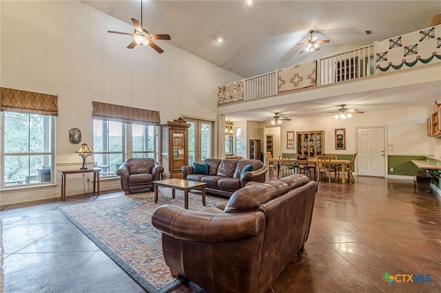 living room featuring ceiling fan and a towering ceiling