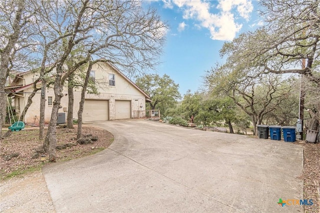 view of side of property with a garage and central AC unit