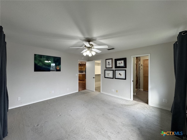 interior space featuring baseboards, a ceiling fan, carpet, and visible vents