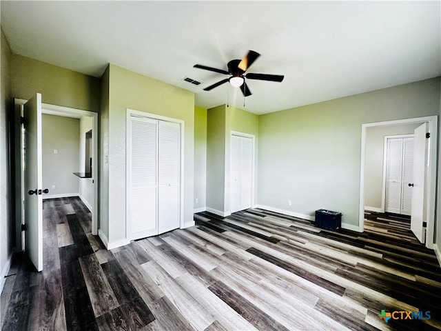 unfurnished bedroom with dark hardwood / wood-style flooring and ceiling fan