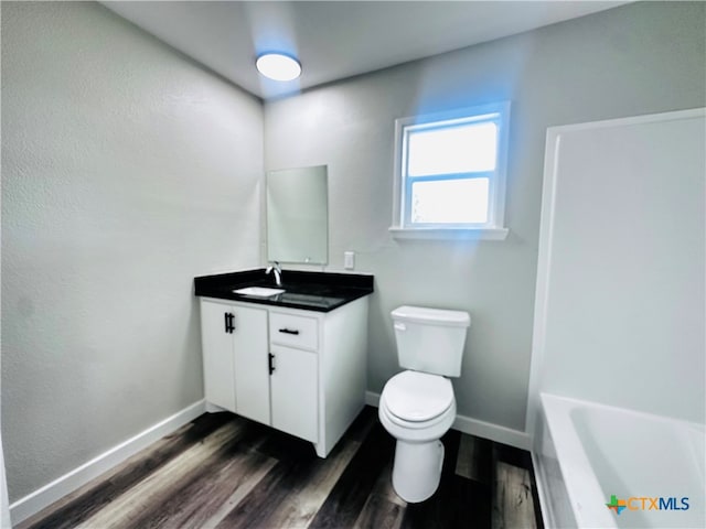 bathroom featuring toilet, vanity, and hardwood / wood-style floors