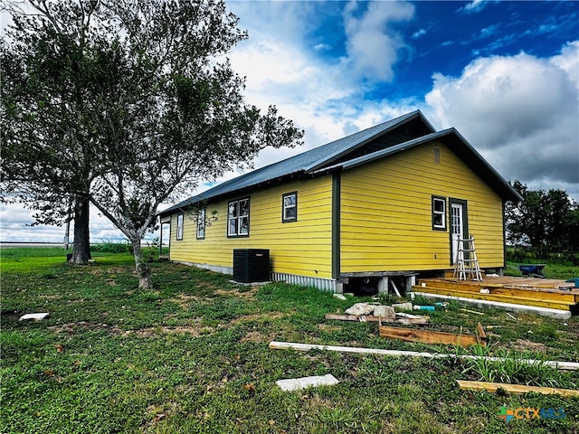 view of side of property featuring a yard and cooling unit