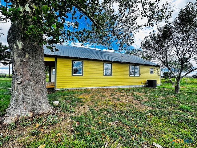 view of home's exterior with central AC unit and a lawn