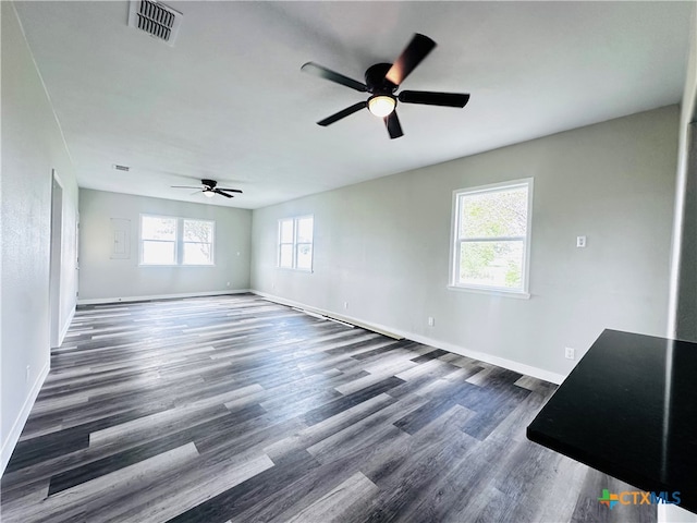 unfurnished room with a wealth of natural light, ceiling fan, and dark hardwood / wood-style flooring