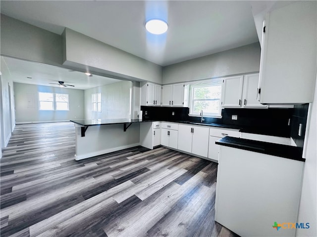 kitchen with dark wood-type flooring, ceiling fan, white cabinetry, and sink