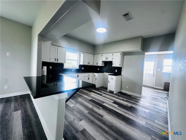 kitchen featuring a wealth of natural light, sink, dark hardwood / wood-style floors, and white cabinets