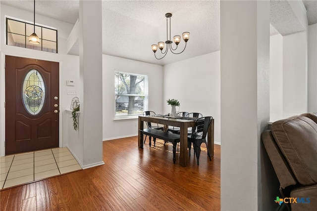 entryway featuring hardwood / wood-style floors, a notable chandelier, and a textured ceiling