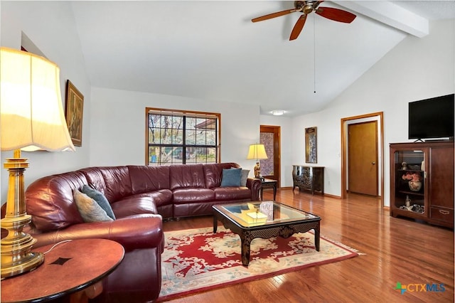 living area featuring beamed ceiling, high vaulted ceiling, wood finished floors, and a ceiling fan