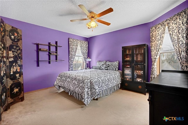 bedroom featuring a textured ceiling, ceiling fan, and carpet flooring