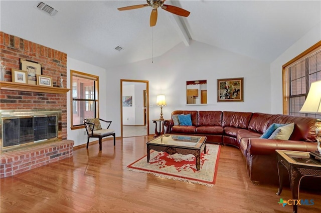 living room with a ceiling fan, beam ceiling, wood finished floors, and visible vents