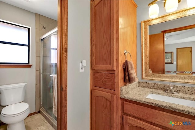 bathroom featuring tile patterned floors, toilet, a stall shower, and vanity