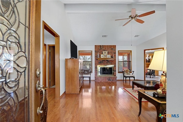 living room featuring ceiling fan, visible vents, plenty of natural light, and light wood-style flooring