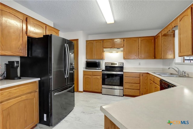 kitchen featuring marble finish floor, under cabinet range hood, a sink, appliances with stainless steel finishes, and light countertops