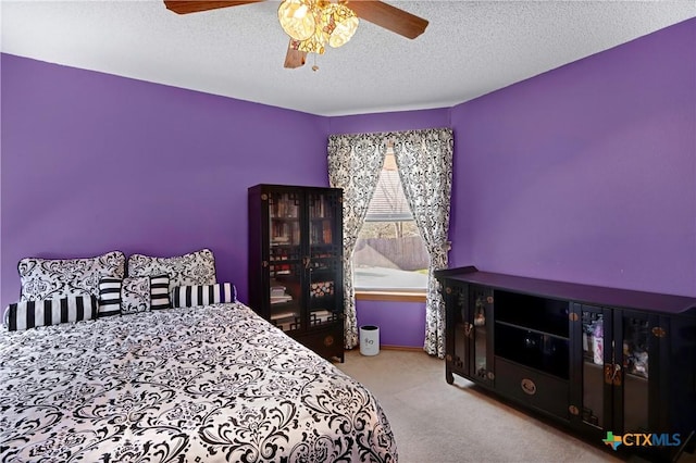 bedroom with a textured ceiling, a ceiling fan, and carpet floors