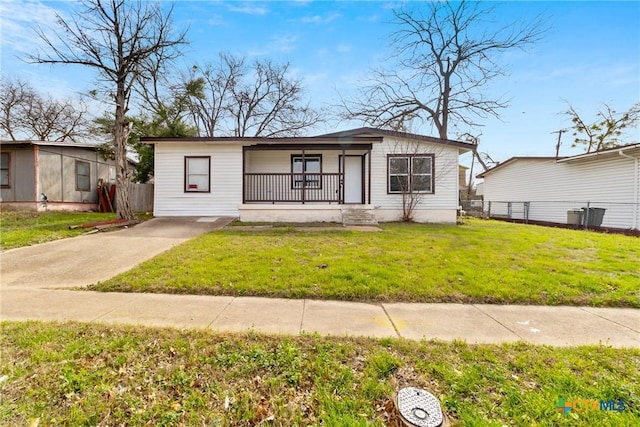 view of front of house featuring covered porch, fence, and a front yard