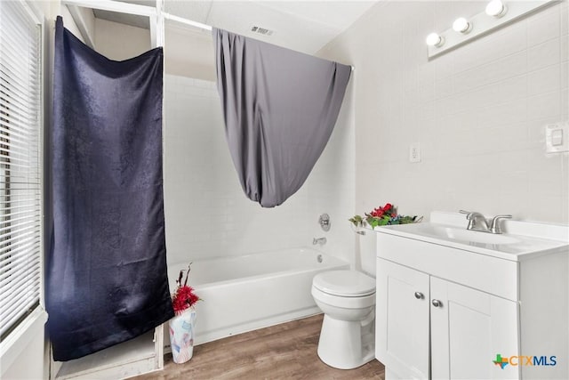 bathroom featuring shower / bathtub combination, vanity, toilet, and wood finished floors