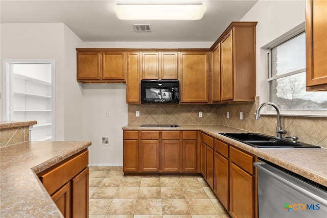 kitchen featuring black appliances, sink, and tasteful backsplash