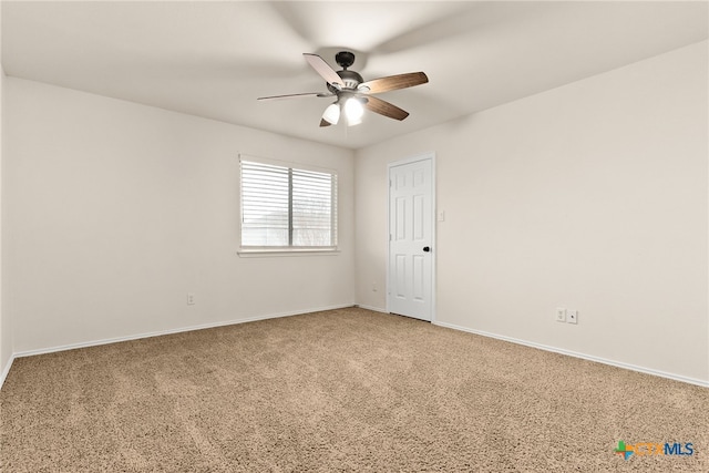 carpeted spare room featuring ceiling fan