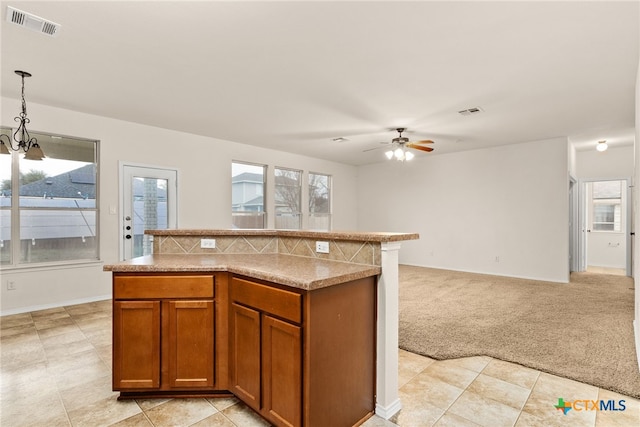 kitchen with ceiling fan with notable chandelier, decorative light fixtures, plenty of natural light, and light colored carpet