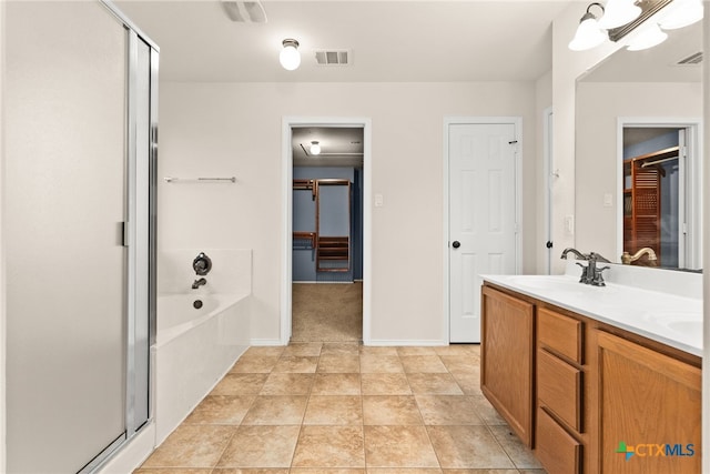 bathroom featuring tile patterned flooring, vanity, and plus walk in shower