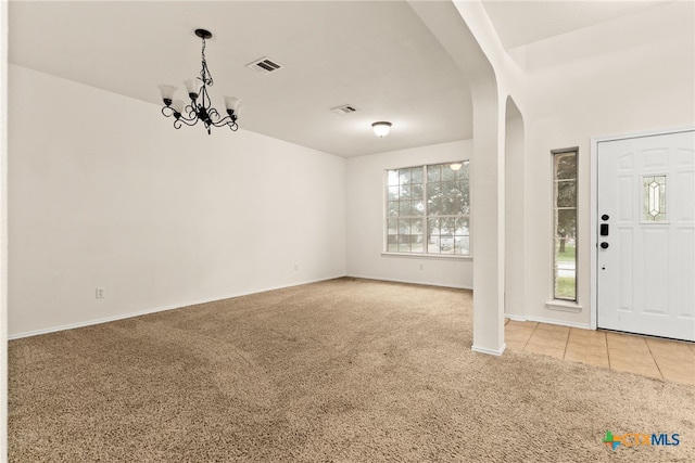 entrance foyer with carpet floors and a chandelier